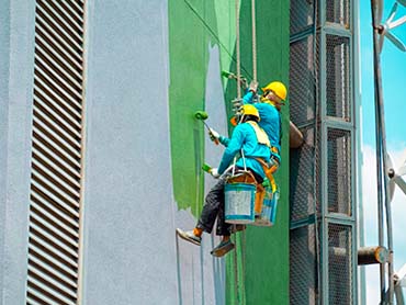 trabajadores pintando edificio<br />
